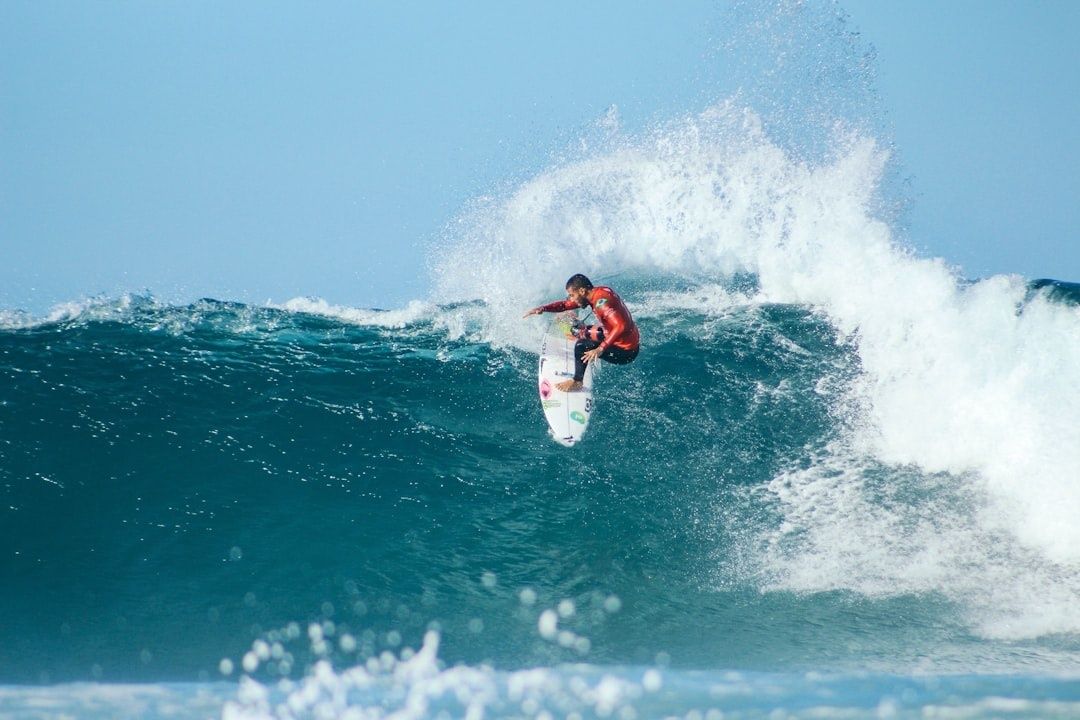 Surfer launches off a powerful breaking wave amid heavy spray