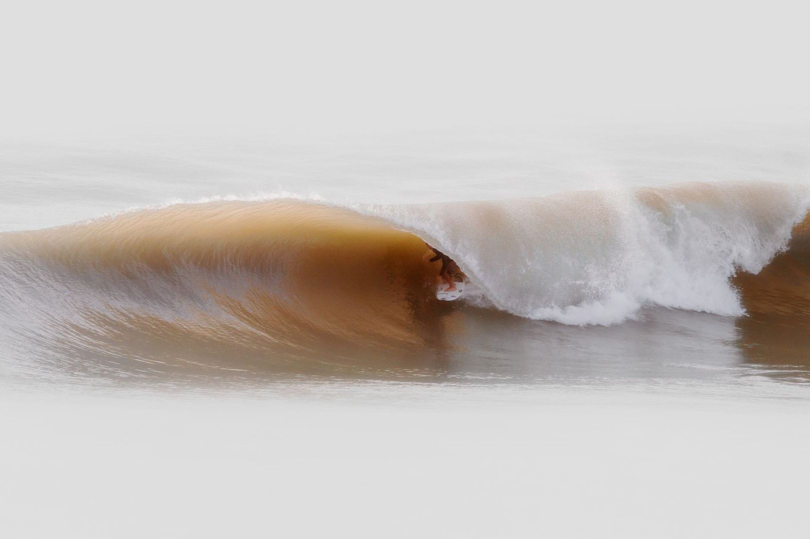 Surfer setting the inside rail on a steep, breaking wave